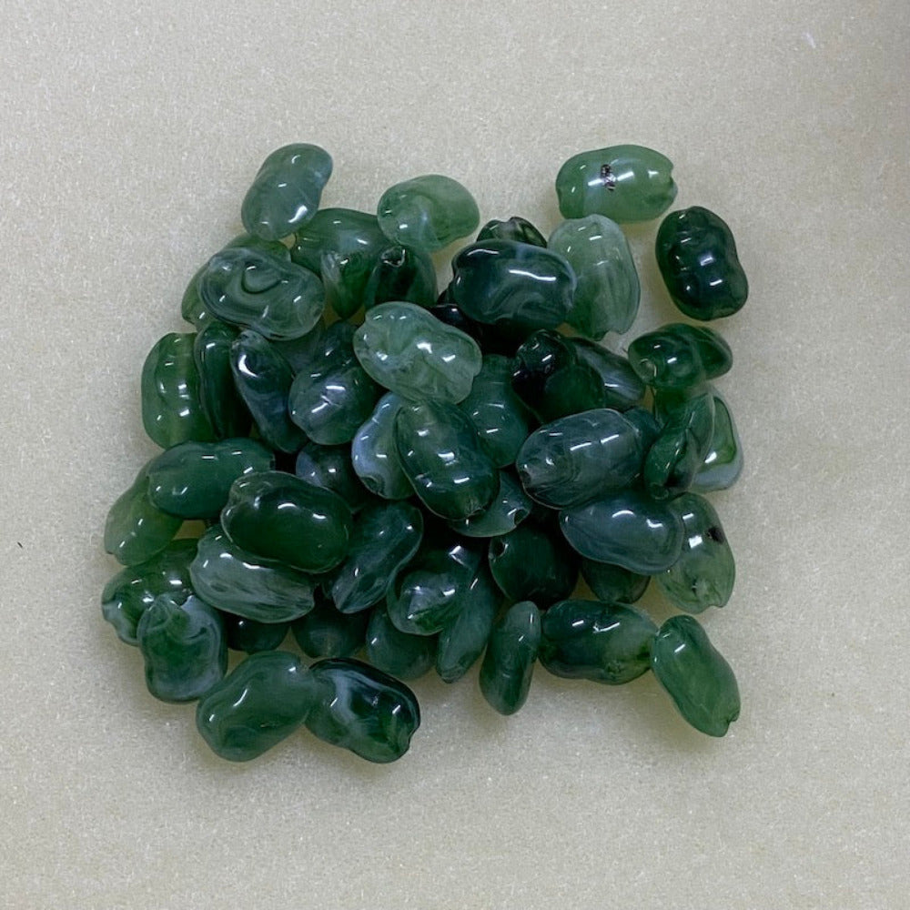 Jade green gemstone style acrylic beads with visible threading holes for crafting jewelry on a white background