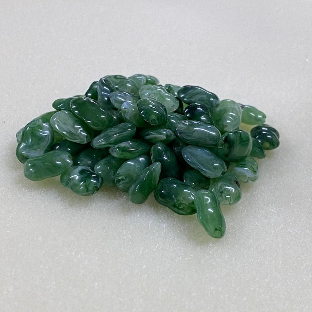Jade green gemstone style acrylic beads with visible threading holes for crafting jewelry on a white background