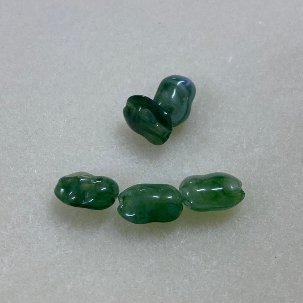 Jade green gemstone style acrylic beads with visible threading holes for crafting jewelry on a white background