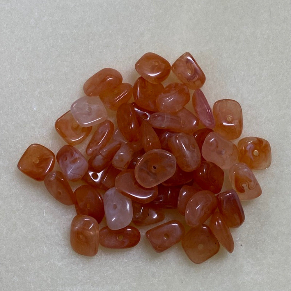 Carnelian orange gemstone style acrylic beads resembling real gemstones, with visible threading holes for crafting jewelry on a white background, used for crafting and jewelry making.