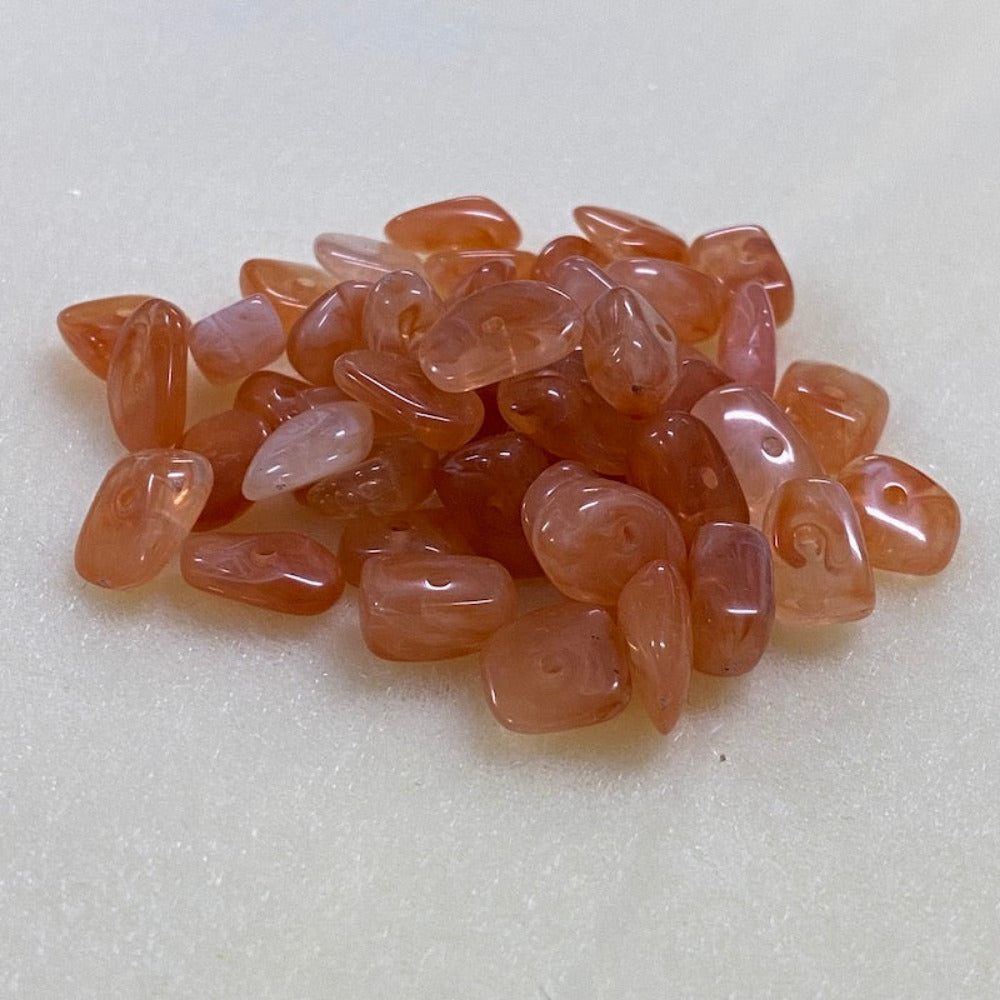 Carnelian orange gemstone style acrylic beads resembling real gemstones, with visible threading holes for crafting jewelry on a white background, used for crafting and jewelry making.