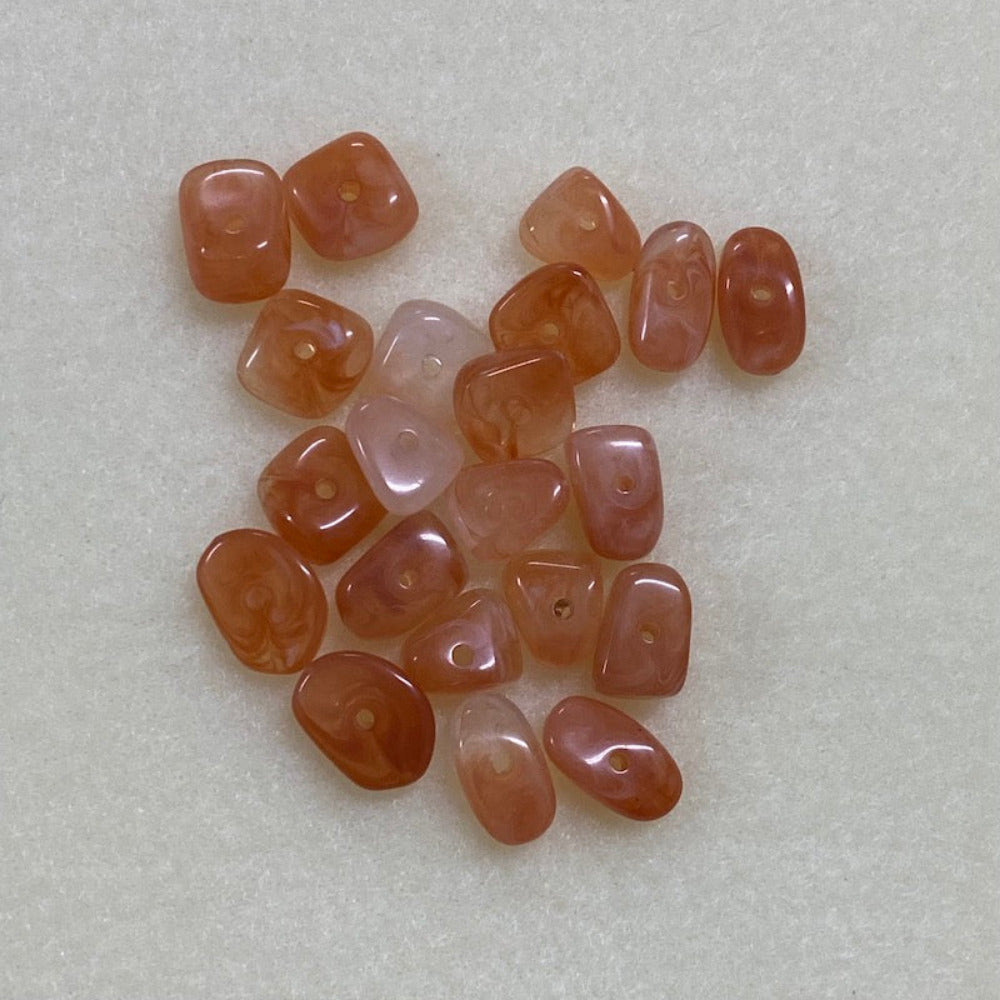 Carnelian orange gemstone style acrylic beads resembling real gemstones, with visible threading holes for crafting jewelry on a white background, used for crafting and jewelry making.