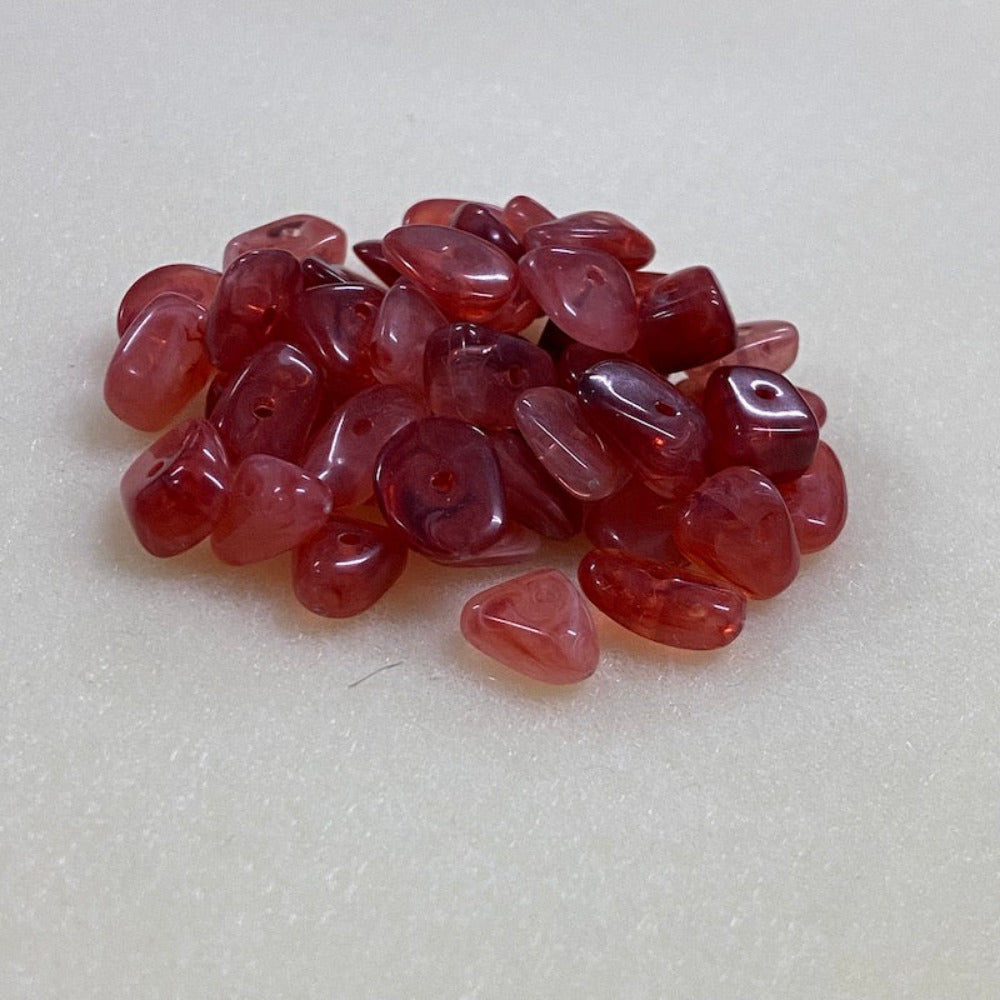 ruby look acrylic beads with visible threading holes for crafting jewelry on a white background