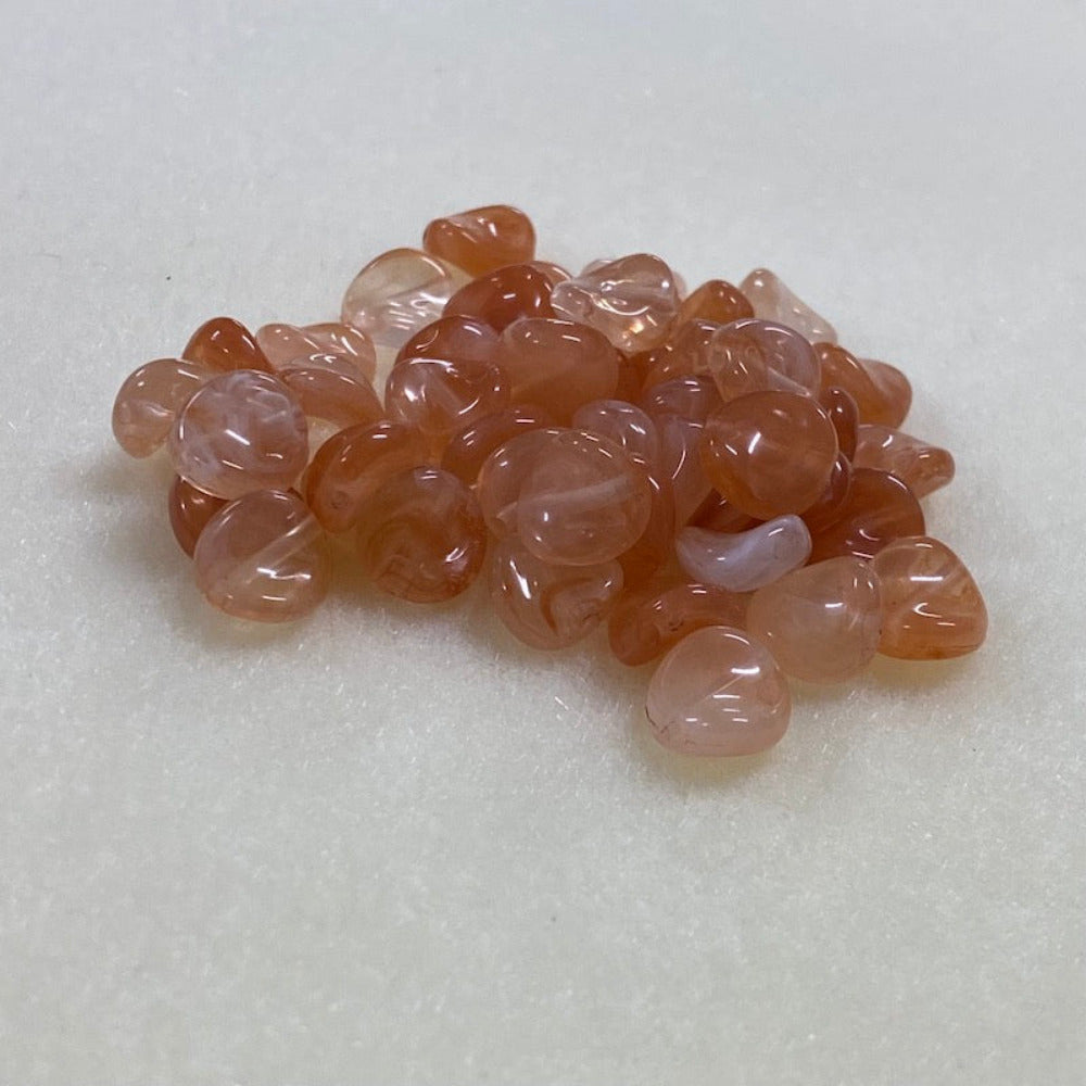 Carnelian orange gemstone style acrylic beads resembling real gemstones, with visible threading holes for crafting jewelry on a white background, used for crafting and jewelry making.