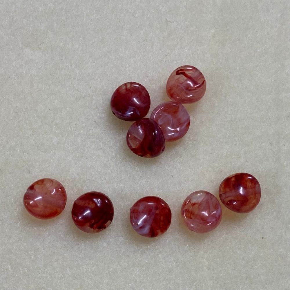 ruby gemstone style acrylic beads with visible threading holes for crafting jewelry on a white background