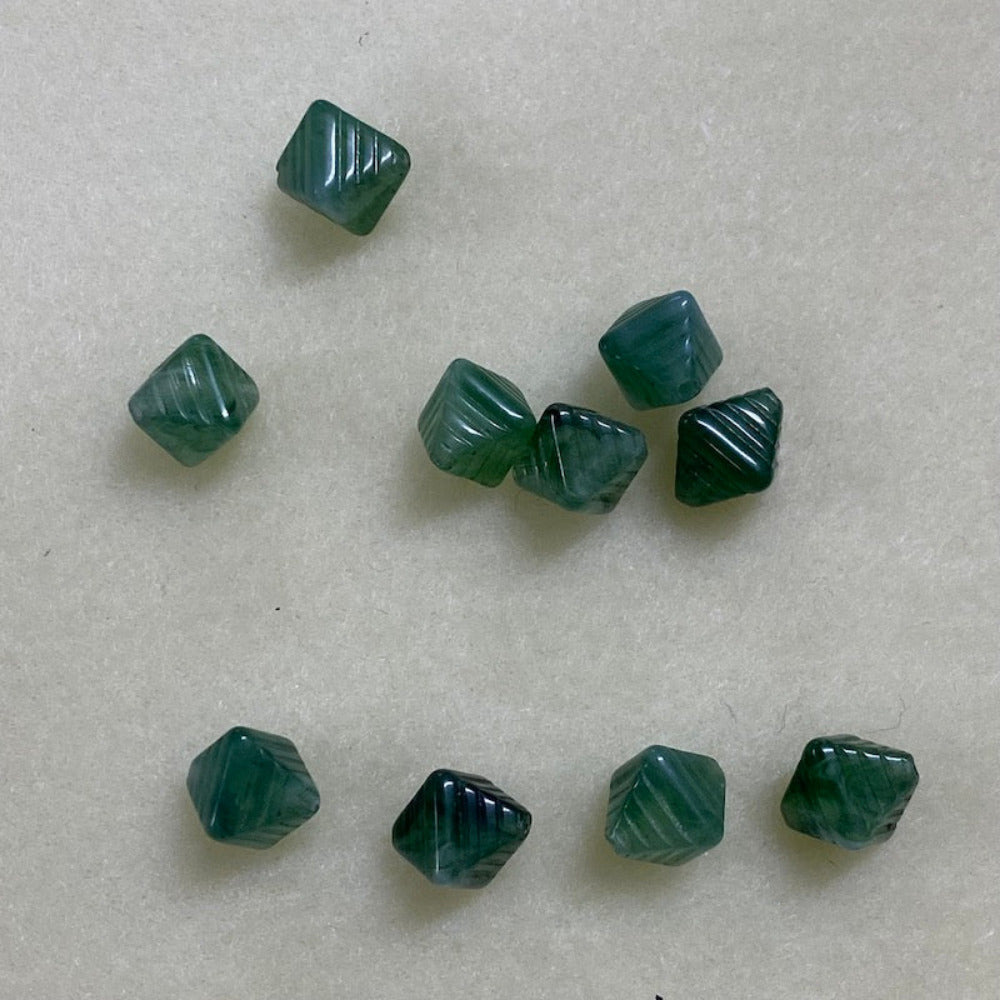Jade green gemstone style acrylic beads with visible threading holes for crafting jewelry on a white background