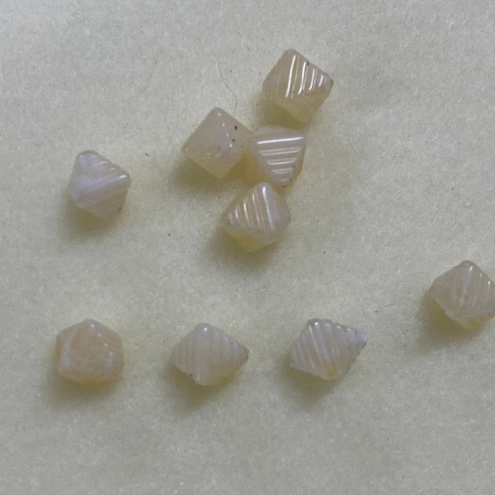 Citrine yellow gemstone style acrylic beads with visible threading holes for crafting jewelry on a white background