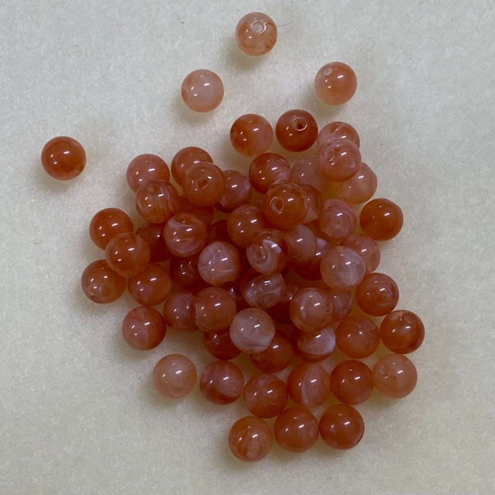 Carnelian orange gemstone style acrylic beads resembling real gemstones, with visible threading holes for crafting jewelry on a white background, used for crafting and jewelry making.
