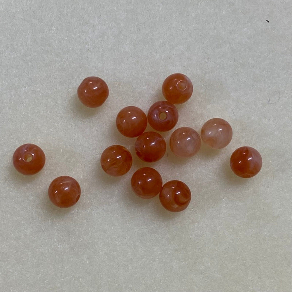 Carnelian orange gemstone style acrylic beads resembling real gemstones, with visible threading holes for crafting jewelry on a white background, used for crafting and jewelry making.