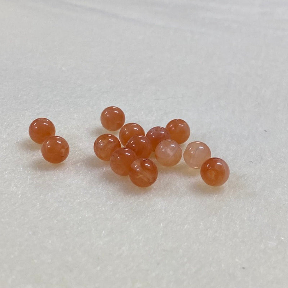 Carnelian orange gemstone style acrylic beads resembling real gemstones, with visible threading holes for crafting jewelry on a white background, used for crafting and jewelry making.