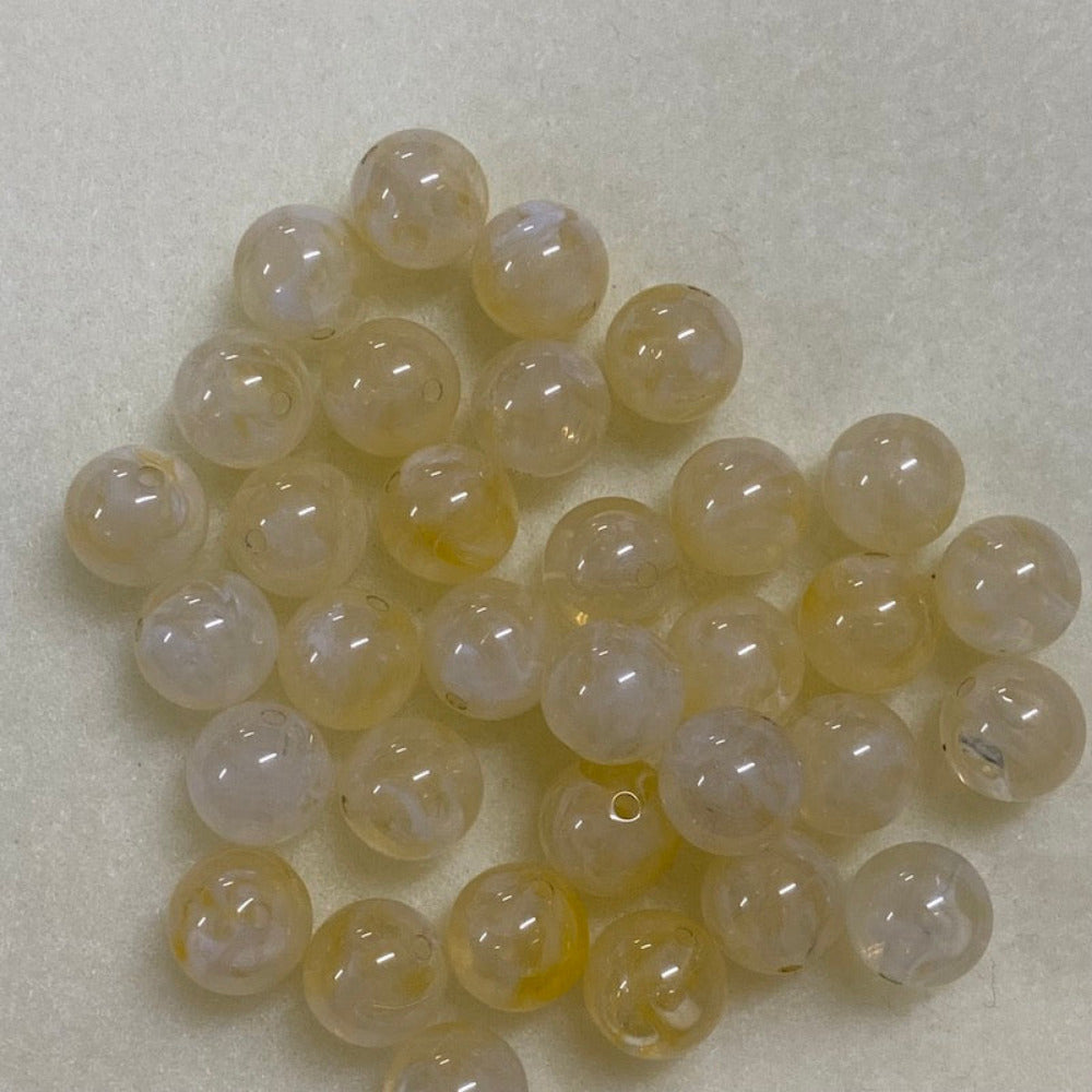 Citrine yellow gemstone style acrylic beads with visible threading holes for crafting jewelry on a white background