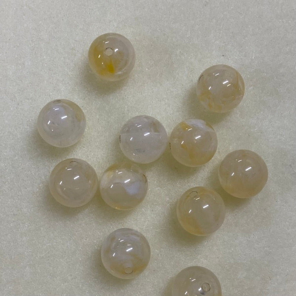 Citrine yellow gemstone style acrylic beads with visible threading holes for crafting jewelry on a white background