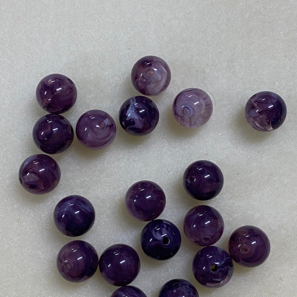 Amethyst purple gemstone style acrylic beads resembling real gemstones, with visible threading holes for crafting jewelry on a white background, used for crafting and jewelry making.