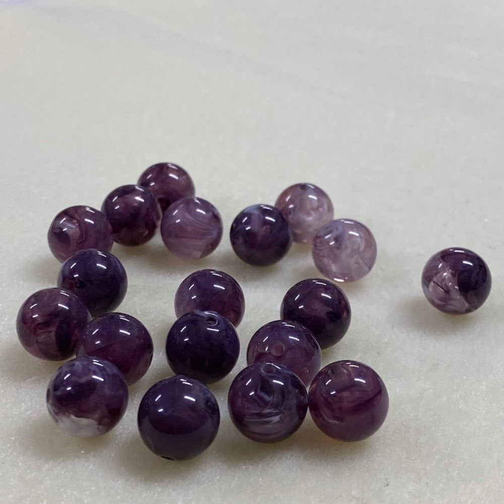 Amethyst purple gemstone style acrylic beads resembling real gemstones, with visible threading holes for crafting jewelry on a white background, used for crafting and jewelry making.