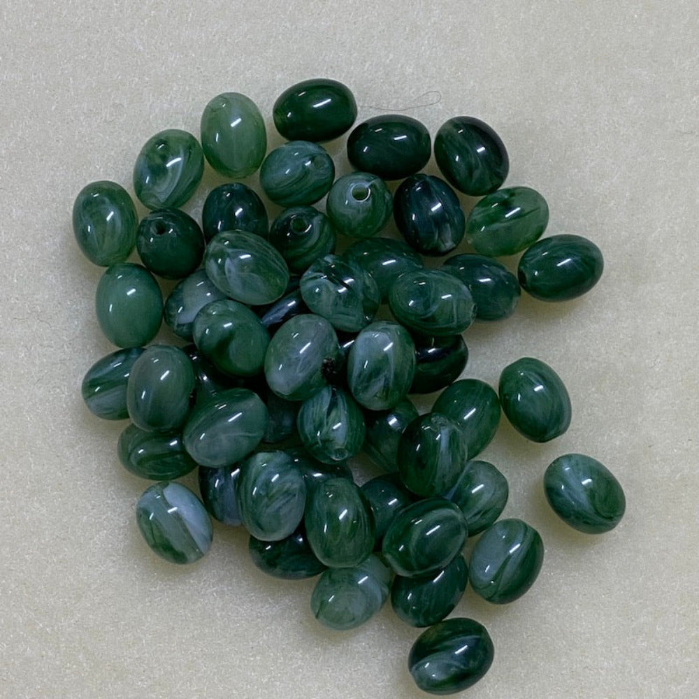 Jade green gemstone style acrylic beads with visible threading holes for crafting jewelry on a white background