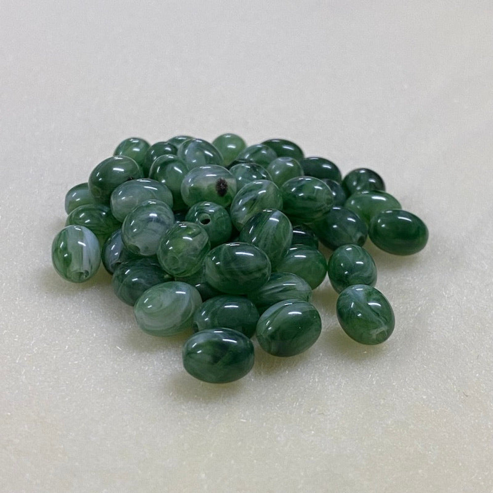 Jade green gemstone style acrylic beads with visible threading holes for crafting jewelry on a white background