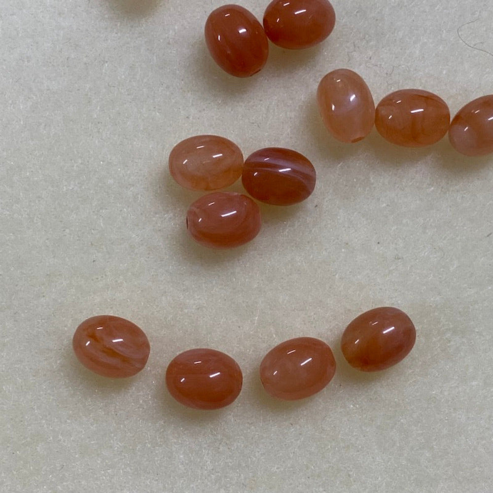 Carnelian orange gemstone style acrylic beads resembling real gemstones, with visible threading holes for crafting jewelry on a white background, used for crafting and jewelry making.