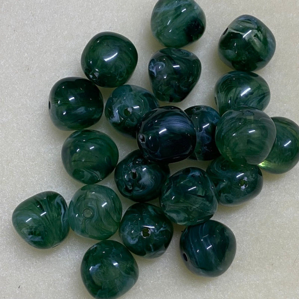 Jade green gemstone style acrylic beads with visible threading holes for crafting jewelry on a white background