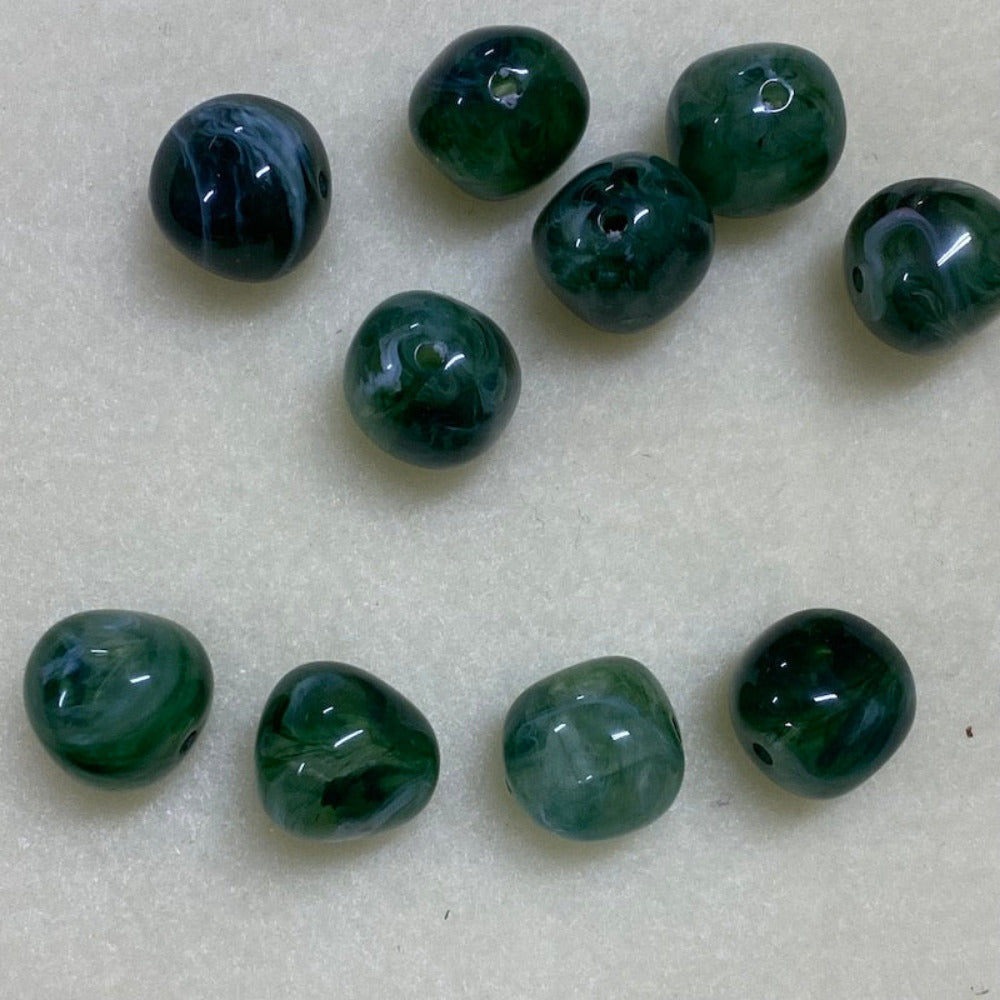 Jade green gemstone style acrylic beads with visible threading holes for crafting jewelry on a white background