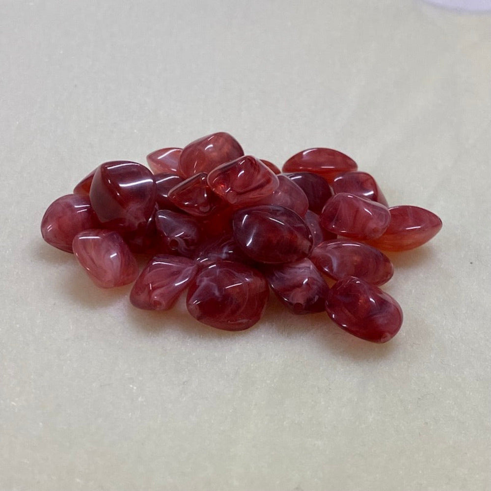ruby look acrylic beads with visible threading holes for crafting jewelry on a white background