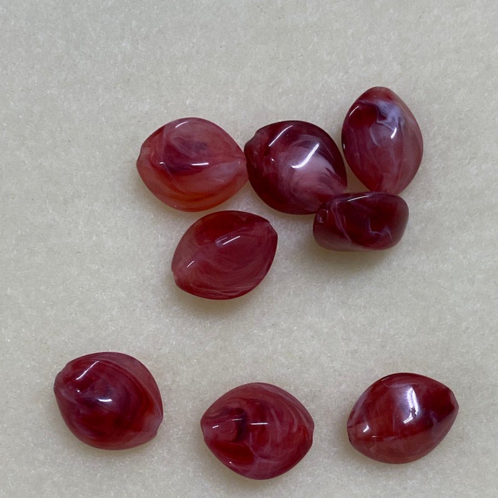 ruby look acrylic beads with visible threading holes for crafting jewelry on a white background