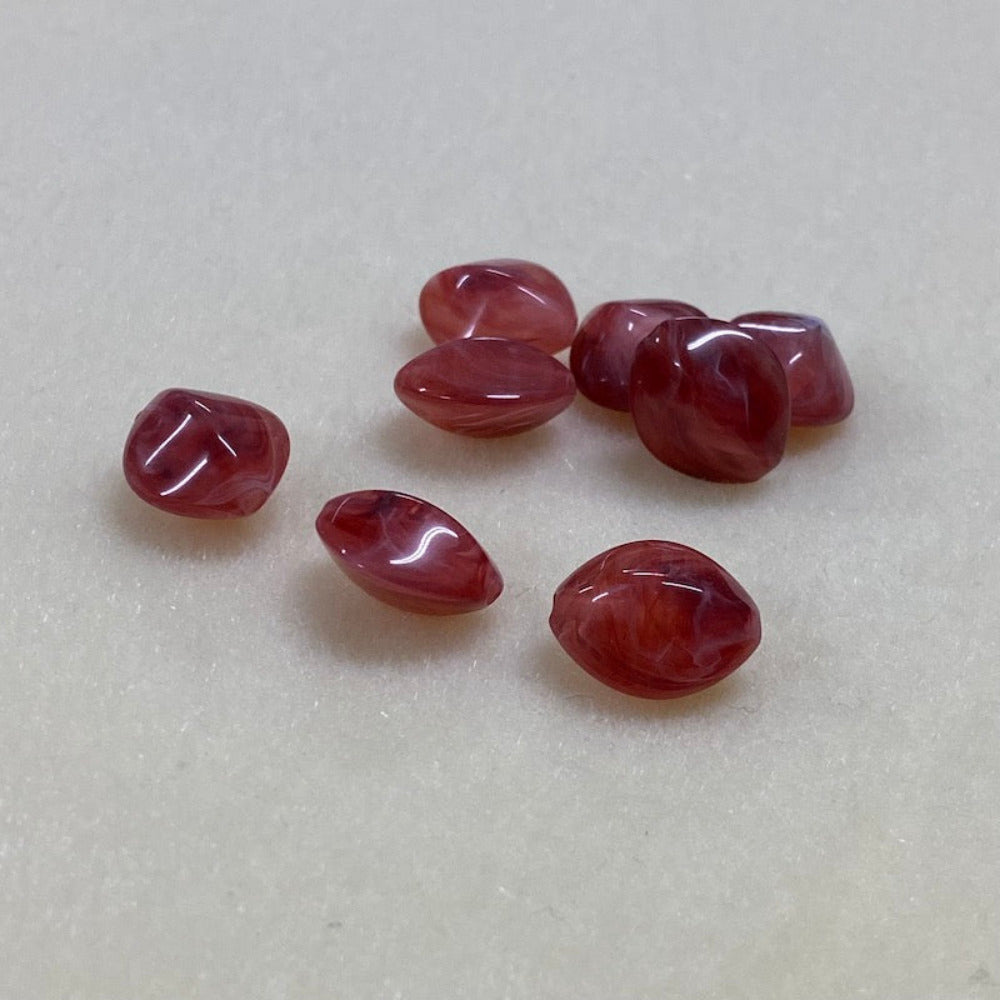 ruby look acrylic beads with visible threading holes for crafting jewelry on a white background