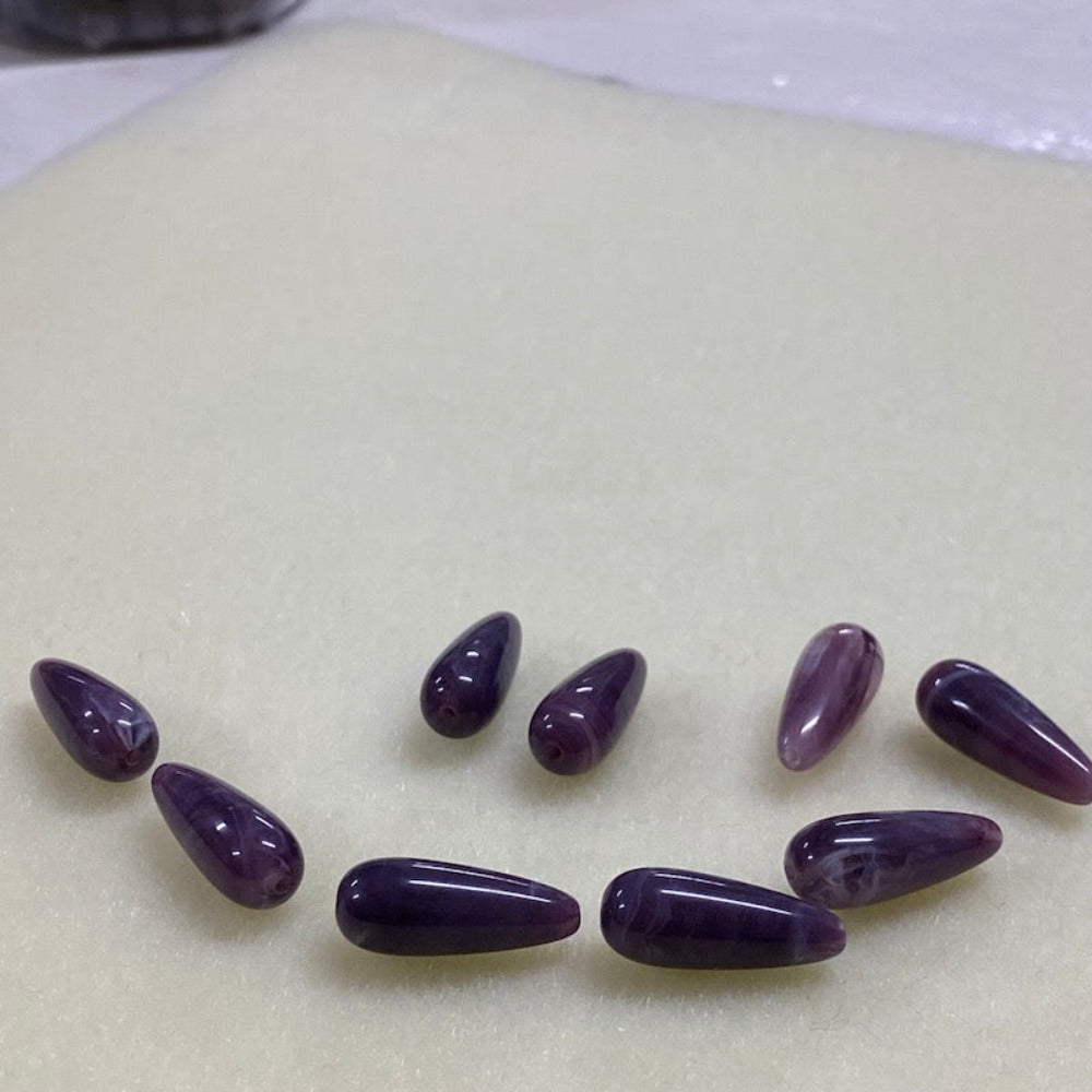 Amethyst purple gemstone style acrylic beads resembling real gemstones, with visible threading holes for crafting jewelry on a white background, used for crafting and jewelry making.
