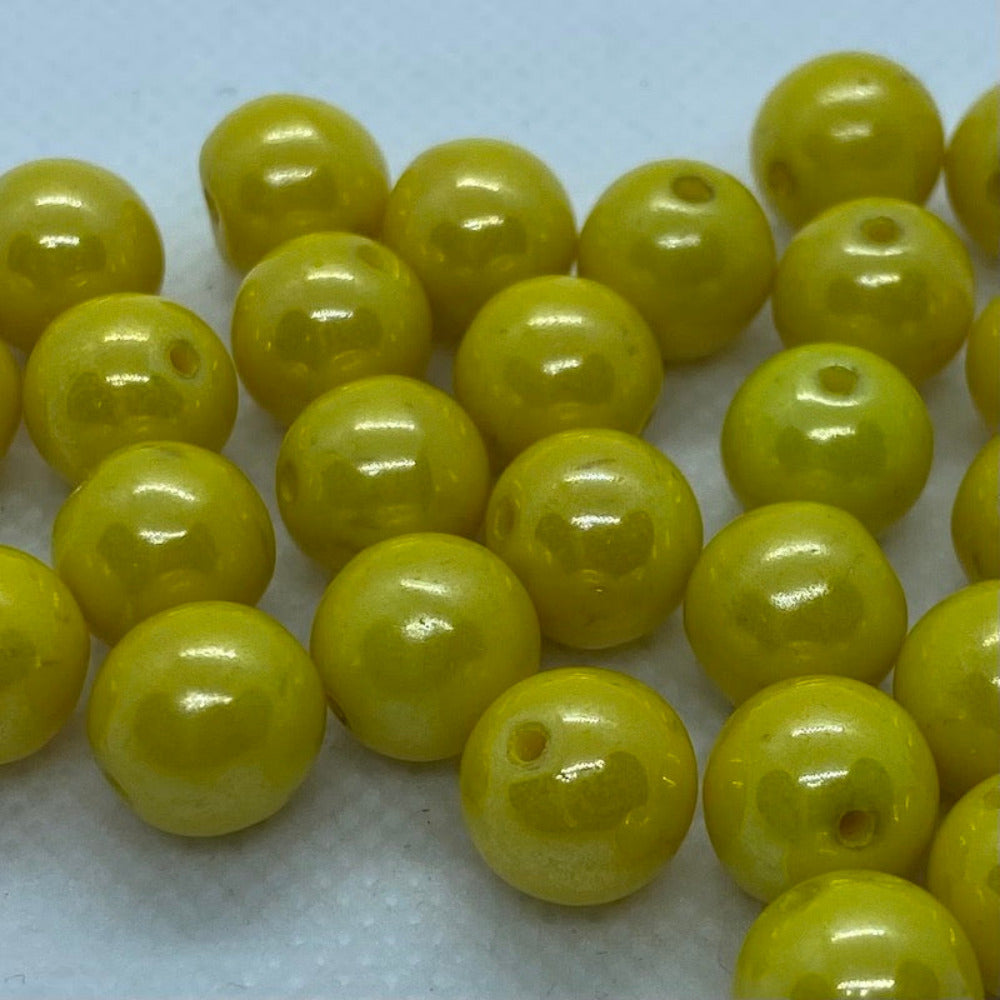 Yellow lustrous round beads on a white surface
