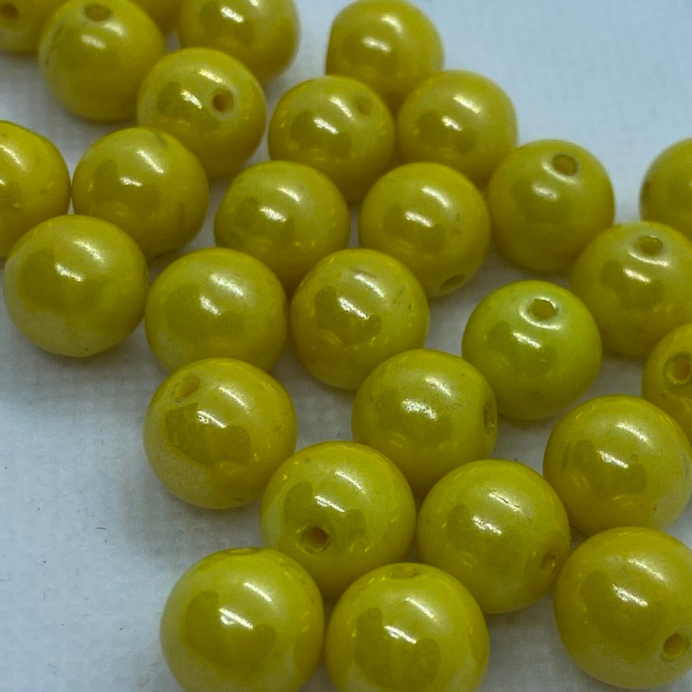 Yellow lustrous round beads on a white surface