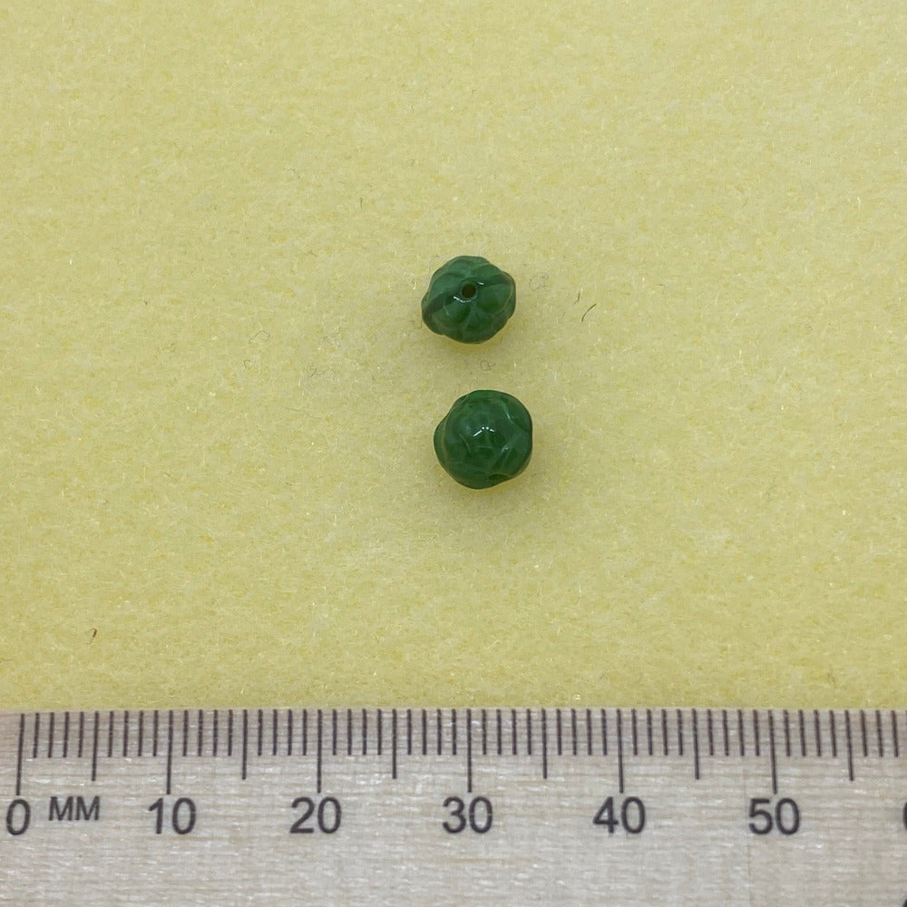 two rose shape beads with patterning on a cream background showing clear threading holes for jewelry making