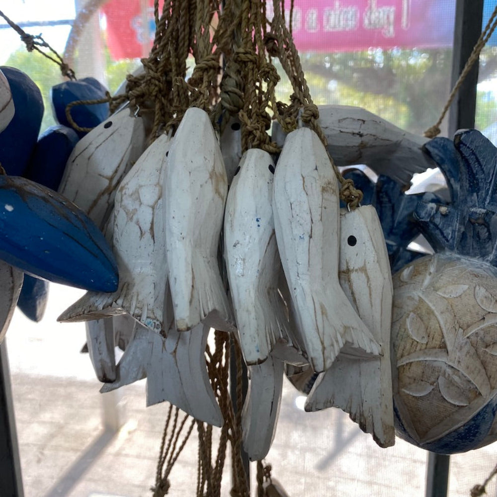 Wood blue and white fish and pineapple decorations in a shop window