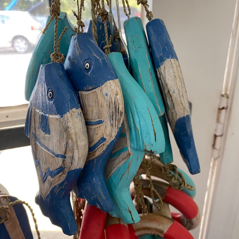 Wood blue and white fish and red and white and blue buoy decorations in a shop window