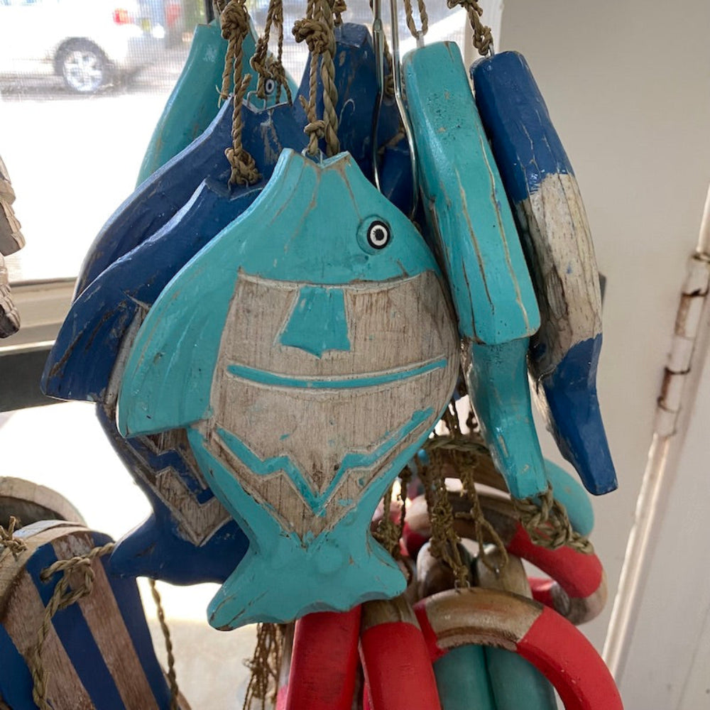 Wood blue and white fish and red and white and blue buoy decorations in a shop window
