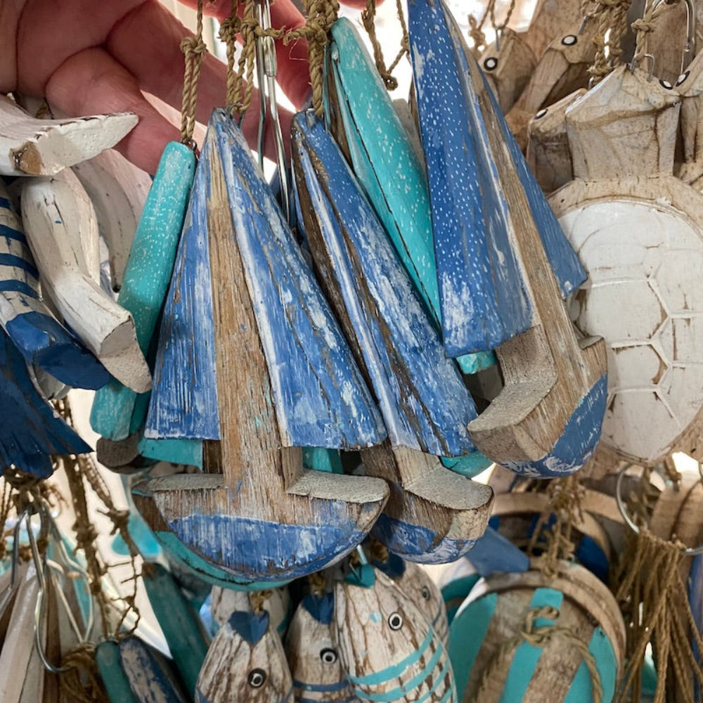 Wood blue and white yacht boat decorations with other shapes of fish thong and turtles in the background, strung on seagrass natural cord