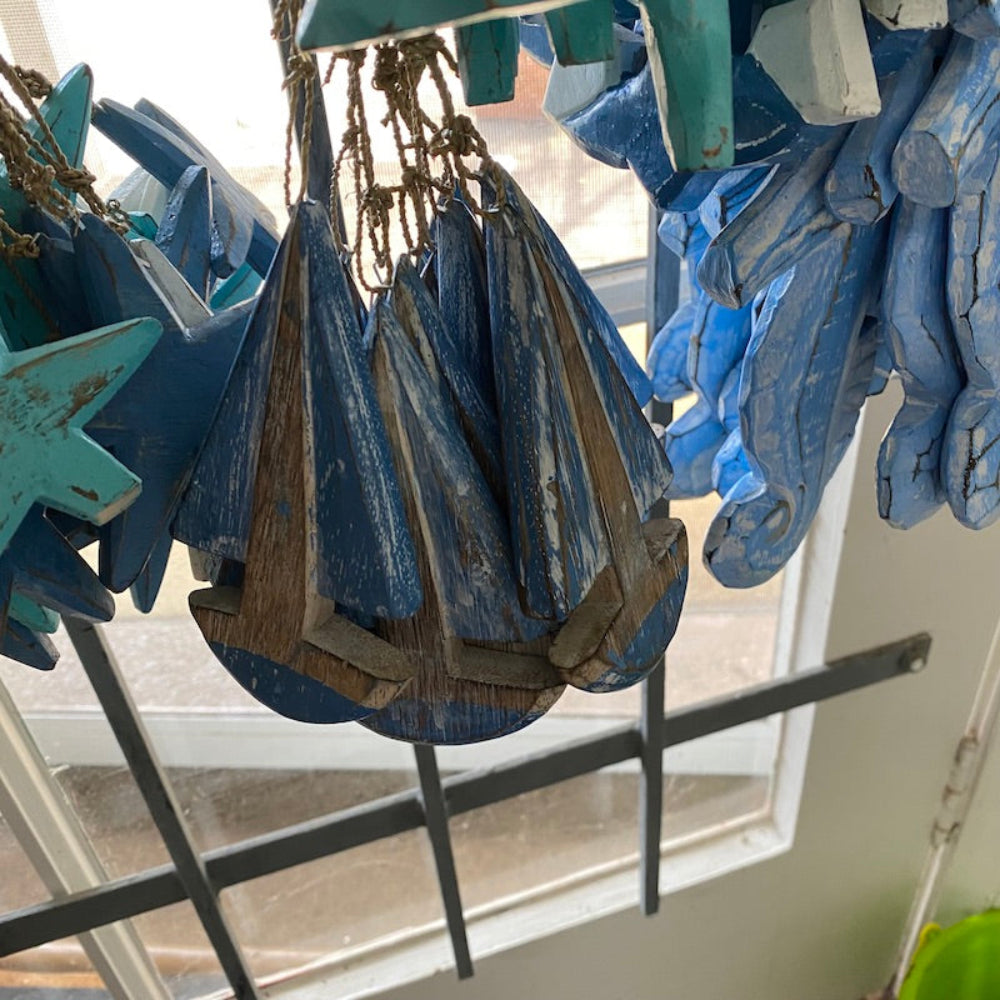 Wood blue and white sailing ships decorations in a shop window also showing seahorses and stars