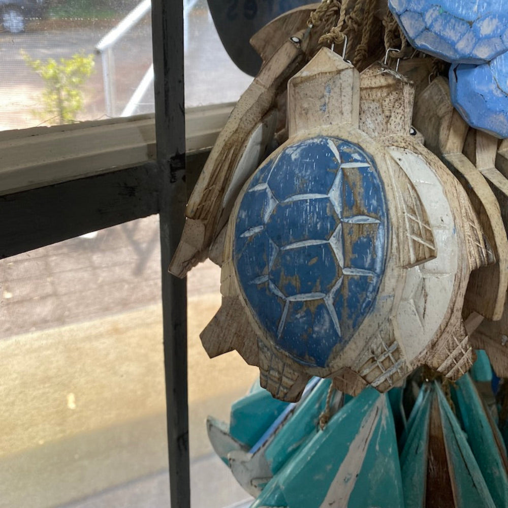 Wood blue and white turtles as well as light blue turquoise and white sailing yacht boat decorations in a shop window