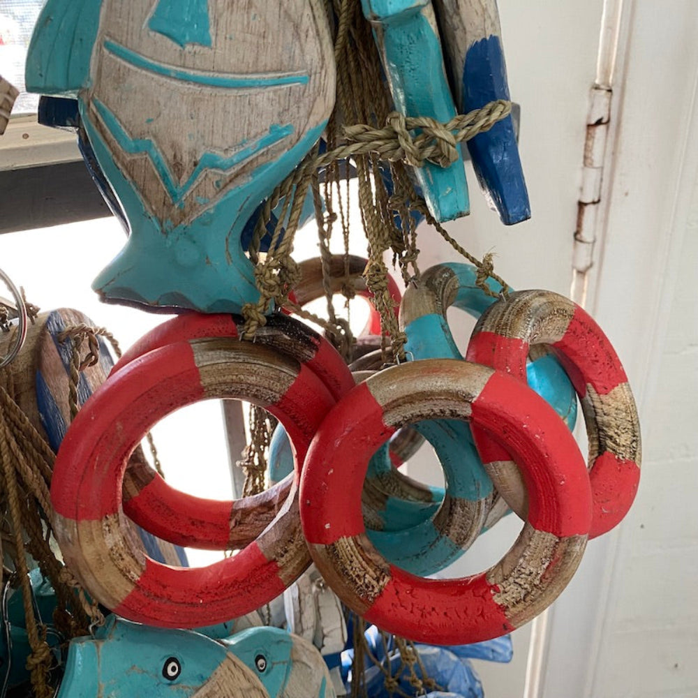 bue and white and red and white wood decoration buoys in a sea theme hanging in a shop window