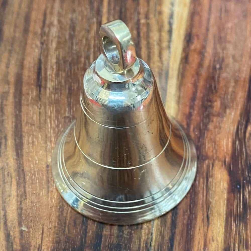 handmade brass bell on a wooden surface for the purpose of decoration and craft