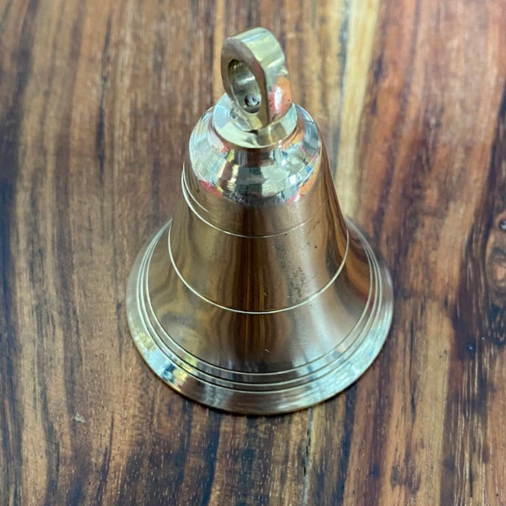 handmade brass bell on a wooden surface for the purpose of decoration and craft