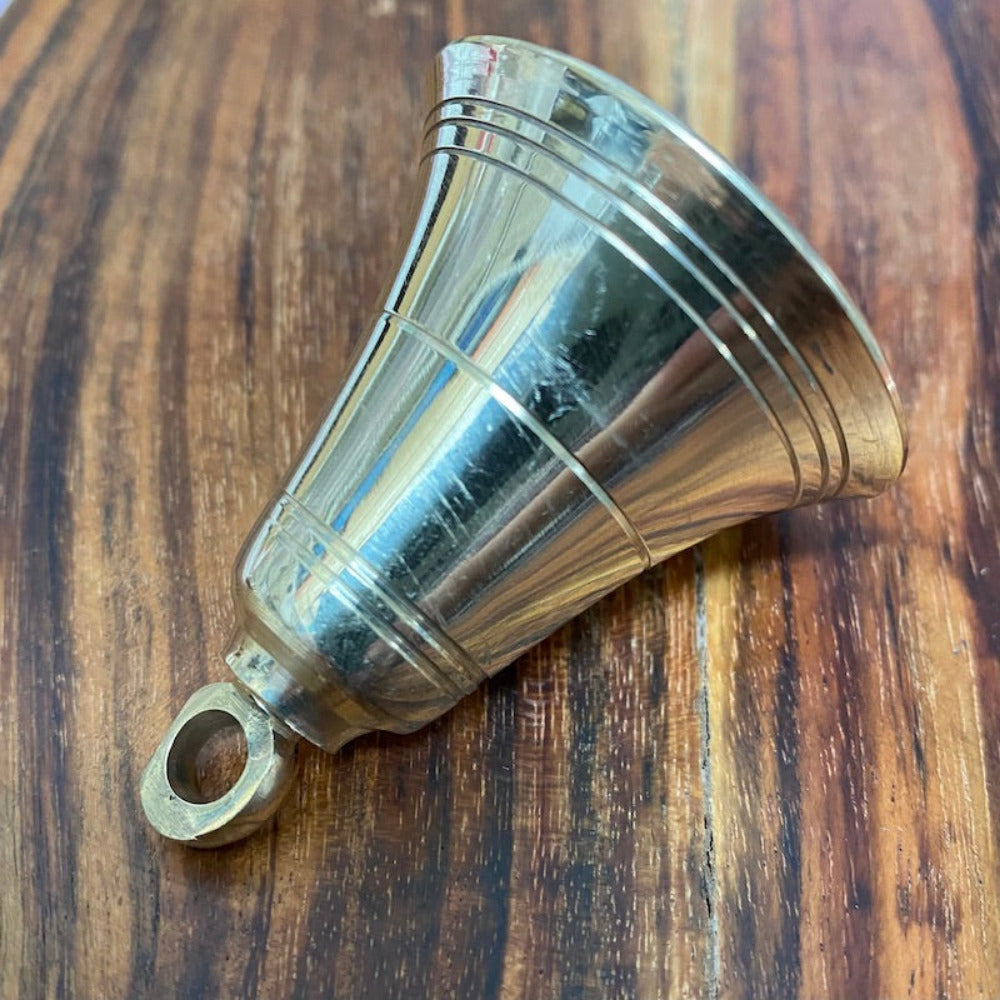 handmade brass bell on a wooden surface for the purpose of decoration and craft