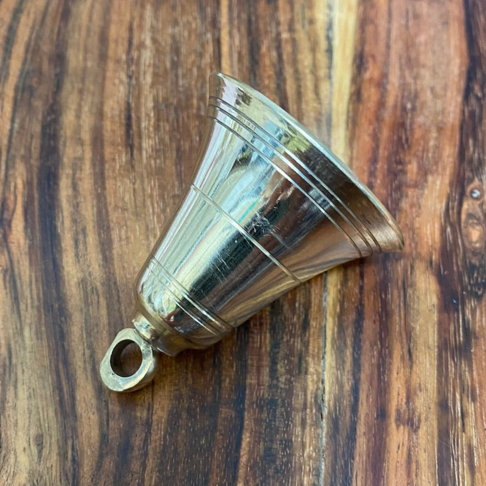 handmade brass bell on a wooden surface for the purpose of decoration and craft