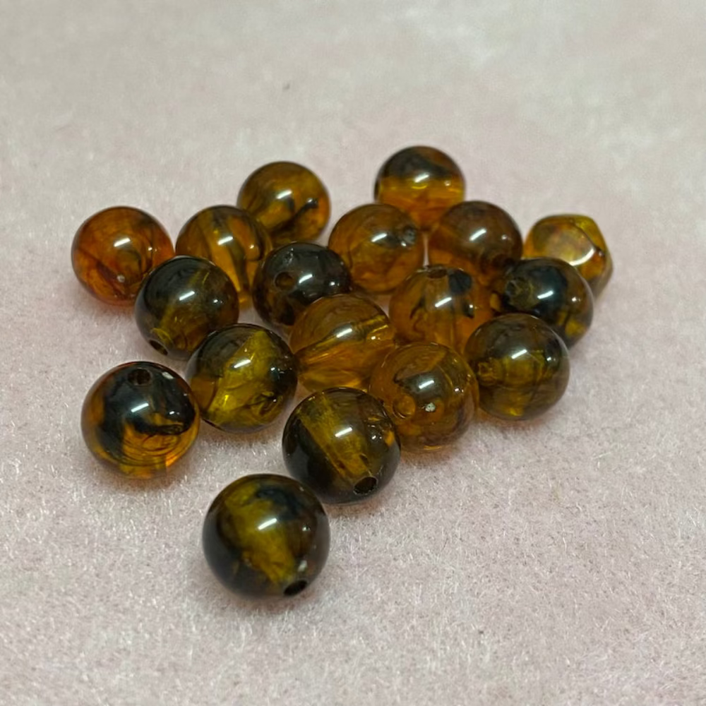 transparent amber beads with a pink surface in the background