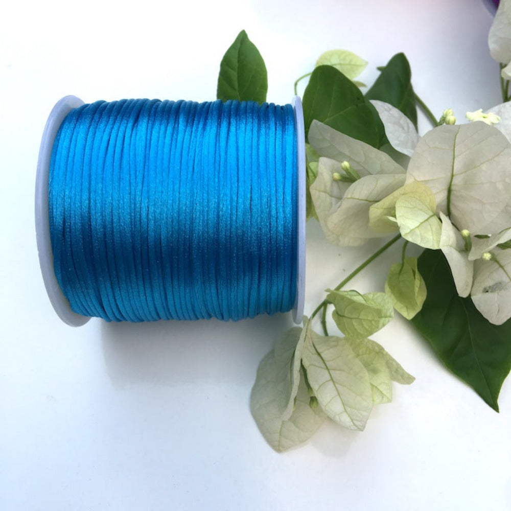 A spool of turquoise blue rat tail cord used for crafting and jewellery making.