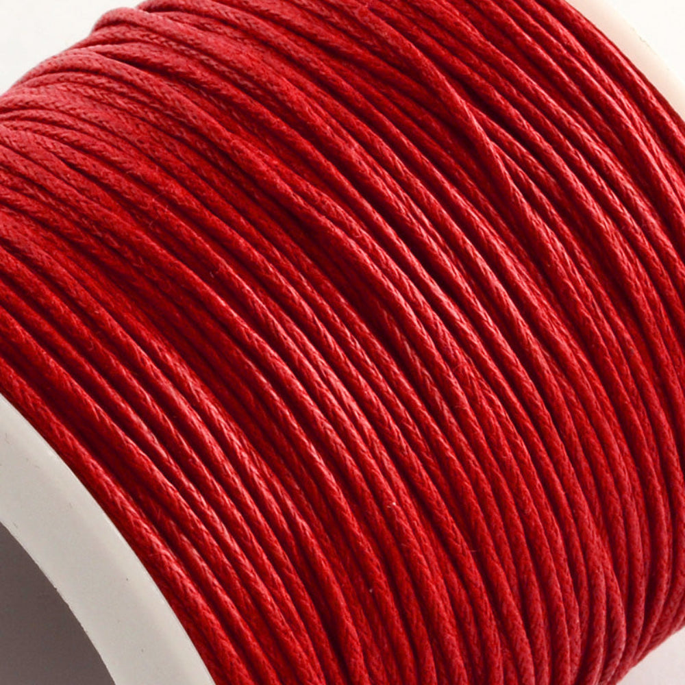 A spool of red wax cotton cord used for crafting and jewelry making.