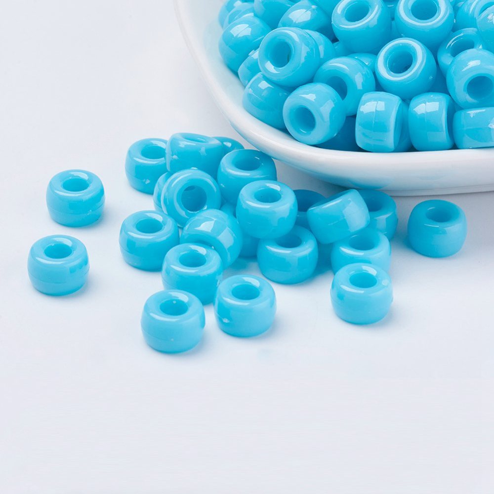 large hole plastic pony beads for the purpose of making craft and jewelry displayed in a bowl on a white surface