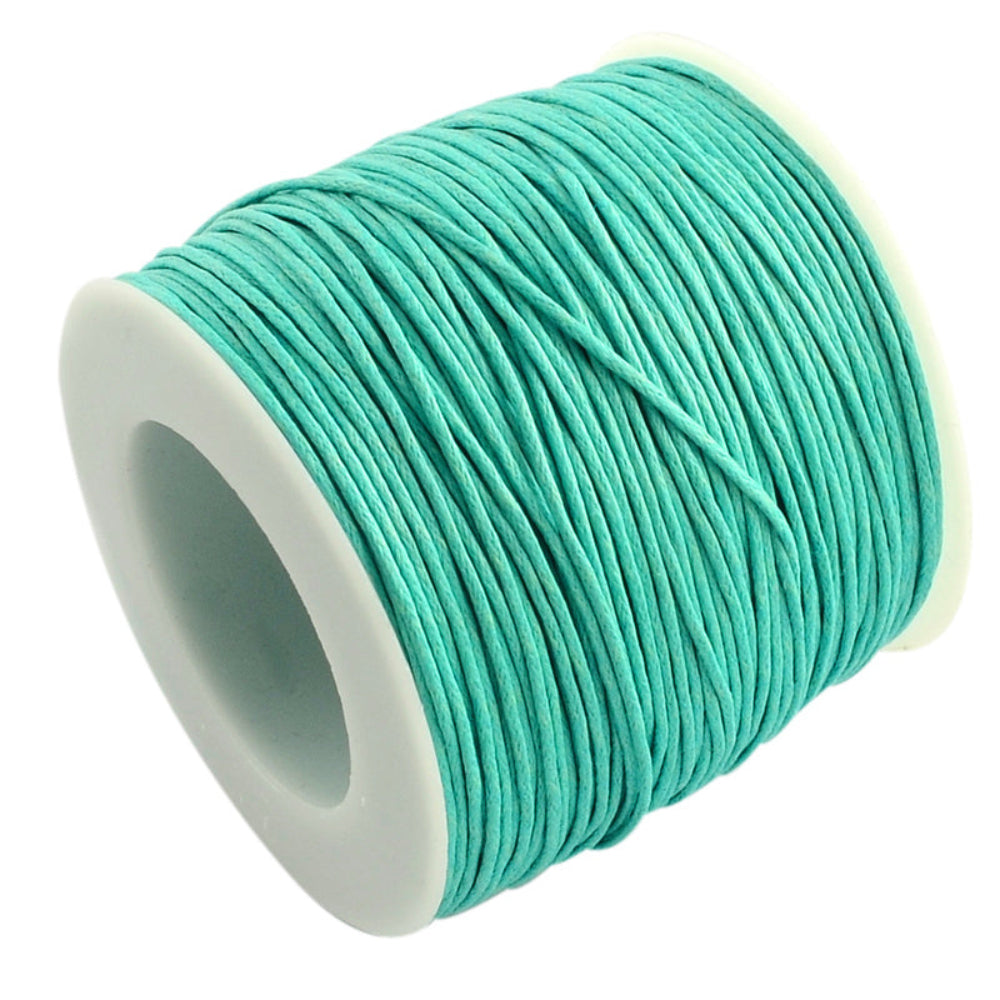 A spool of aqua turquoise wax cotton cord used for crafting and jewelry making.