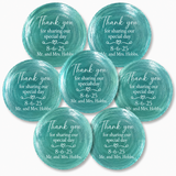 Seven round teal watercolor-style shell place cards with white printed text reading 'Thank you for sharing our special day 8-6-25 Mr. and Mrs.
