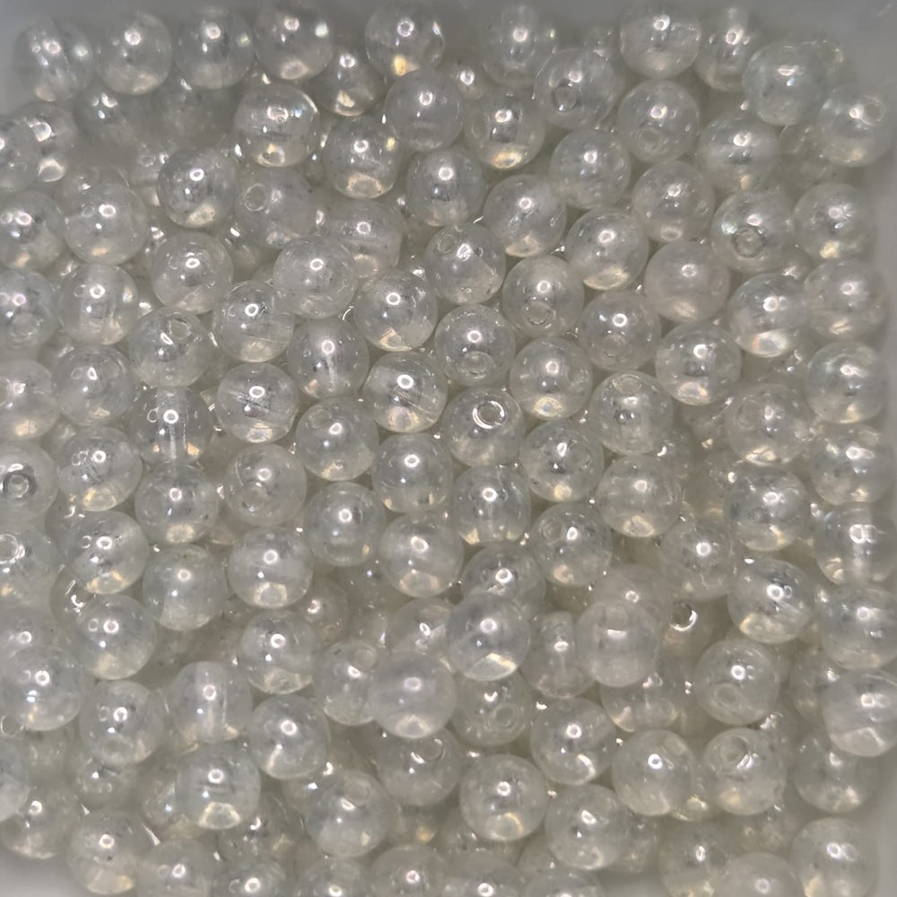 Close-up of clear glass beads on a light gray background