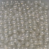 Close-up of clear glass beads on a light gray background