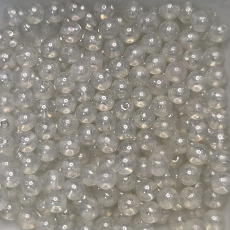 Close-up of clear glass beads on a light gray background